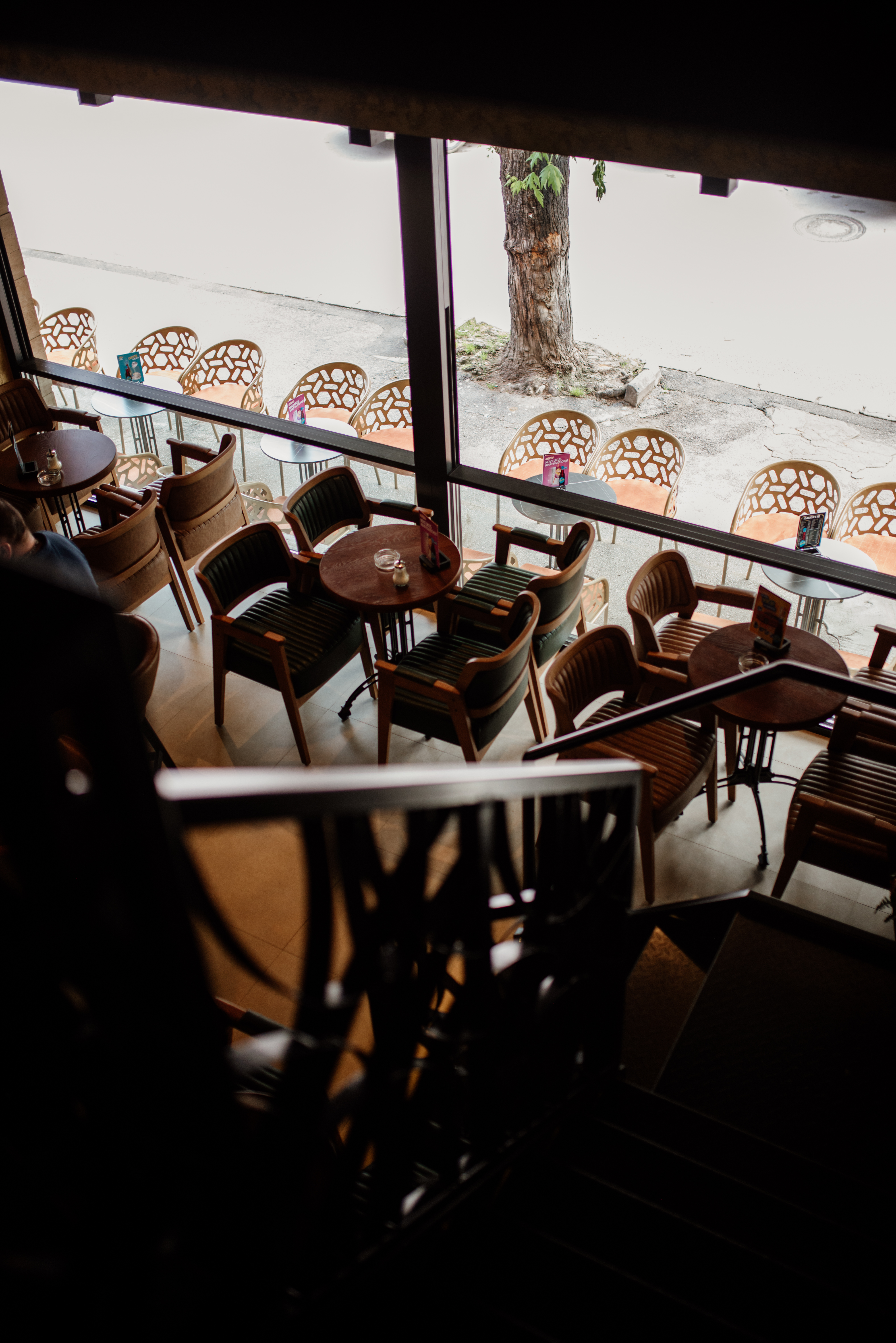 Cozy cafe interior with stylish seating and large windows on a quiet street