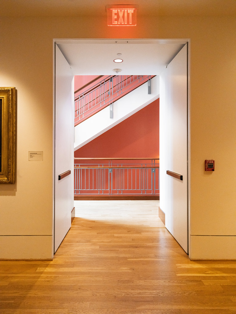 Exit Frame: Red Stairwell and Warm Gallery Lighting at The Phillips Collection